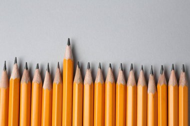 Gri arka planda keskin grafit kalemler, düz. Metin için boşluk