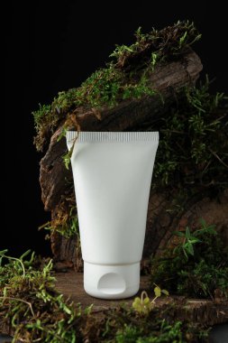 Ağaç kabuğunda bitkilerle birlikte nemlendirici vücut kremi, yakın plan.