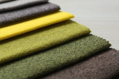 Açık ahşap masadaki farklı kumaşlardan örnekler.