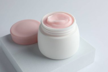 Beyaz arka planda nemlendirici krem kavanozu, yakın plan.