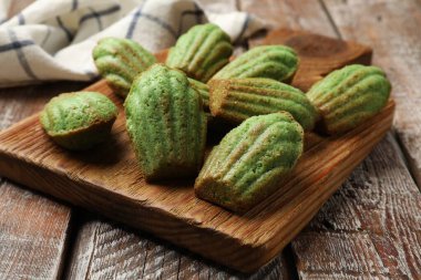 Lezzetli Matcha Madeleine kekleri ahşap masada, yakın plan.