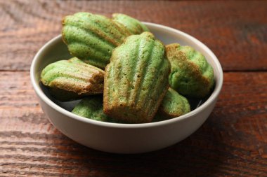 Lezzetli Matcha Madeleine kekleri ahşap masada, yakın plan.