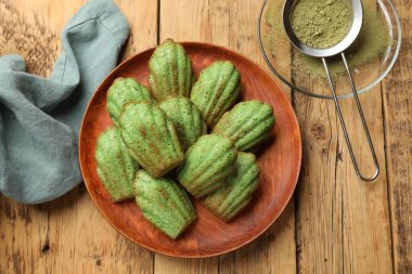 Lezzetli madelaine kekleri ve kibrit tozu ahşap masada, düz yatıyordu.
