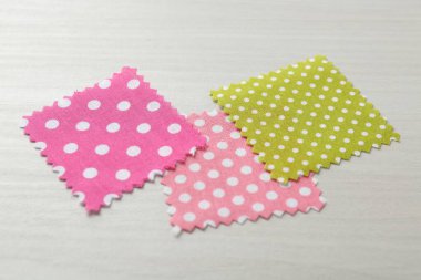 Beyaz ahşap masadaki farklı kumaşlardan örnekler, yakın plan.