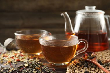 Bitki çayı ve kuru yaprakları ahşap masaya serpmek, yakın çekim. Metin için boşluk