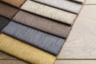 Tahta masadaki farklı kumaşlardan örnekler, yakın plan.