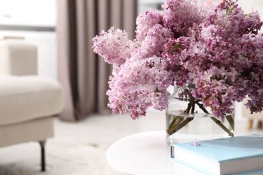 Vazodaki güzel leylak çiçekleri ve içerideki masada kitap, metin için yer