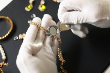 Masadaki lüks mücevherleri değerlendiren eksper.