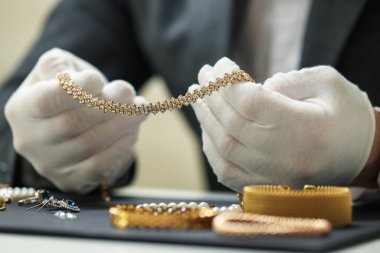 Kapalı bir masada lüks takılarla çalışan bir eksper.