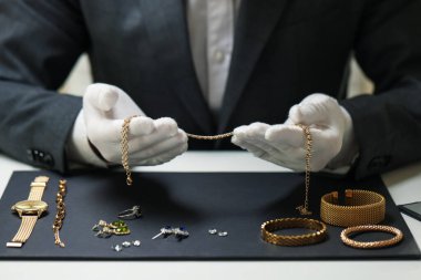 Kapalı bir masada lüks takılarla çalışan bir eksper.