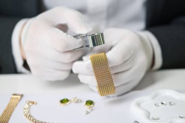 Sofrada lüks bilezik değerlendirmesi yapan bir eksper.