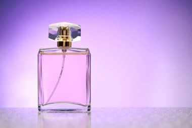 Ayna yüzeyindeki parfüm şişesi menekşe eğimli arkaplan, metin için boşluk