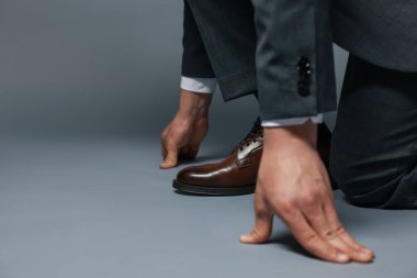 İş adamı gri arka planda başlangıç pozisyonunda, yakın plan. Metin için boşluk