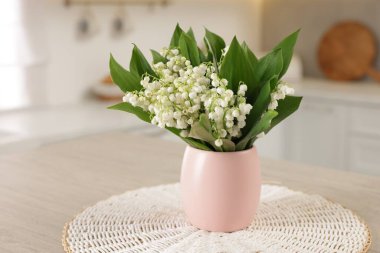 Mutfaktaki ahşap masanın üzerinde güzel bir zambak buketi.