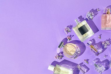 Düz kompozisyon, parfüm şişeleri ve mor arka planda leylak çiçekleri vardı. Metin için boşluk