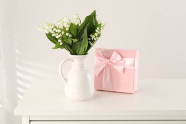 Vadi çiçeklerinin güzel zambakları ve beyaz masada hediyeler.