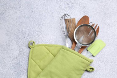 Farklı mutfak aletleri fırın eldivenlerinde, ışık masasında, üst tarafta. Metin için boşluk