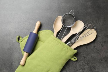 Farklı mutfak aletleri fırın eldivenleri gri masada, düz yatıyordu.