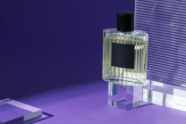 Mor arka planda parfüm şişesinin şık sunumu, yakın plan. Metin için boşluk