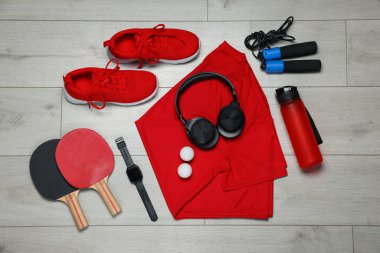 Spor kıyafetleri ve yerde kulaklıkları olan düz bir kompozisyon.