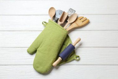 Farklı mutfak aletleri fırın eldiveni beyaz ahşap masa, üst görünüm