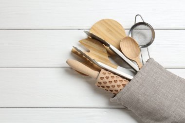 Fırın eldivenindeki farklı mutfak aletleri beyaz ahşap masa, üst manzara. Metin için boşluk