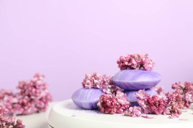 Beyaz masadaki sabun çubukları ve leylak çiçekleri menekşe arka planda, yakın plan. Metin için boşluk