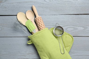 Farklı mutfak gereçleri fırın eldiveni açık gri ahşap masa, üst manzara
