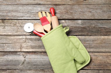 Farklı mutfak aletleri fırın eldiveni ahşap masa, üst görünüm