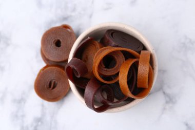 Lezzetli meyve derisi beyaz mermer masada kasede yuvarlanıyor.