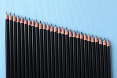 Açık mavi zemin üzerinde birçok keskin grafit kalem, düz yatıyordu