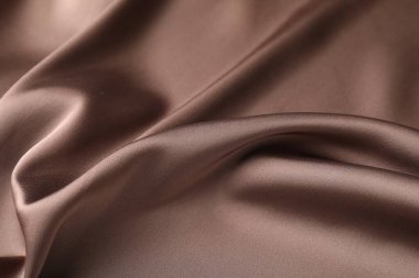 Arkaplan olarak buruşuk açık kahverengi ipek kumaş, yakın plan