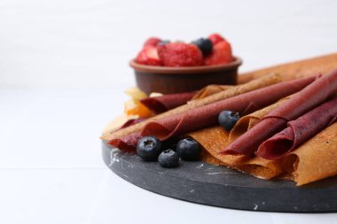 Lezzetli meyve dürümleri ve beyaz masada meyveler, yakın plan. Metin için boşluk