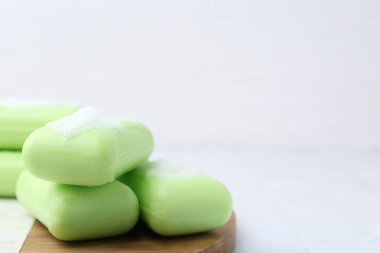 Beyaz masadaki köpüklü sabun çubukları, yakın plan. Metin için boşluk