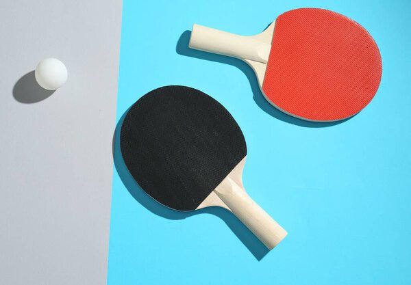 Ping pong rackets and ball on color background, top view