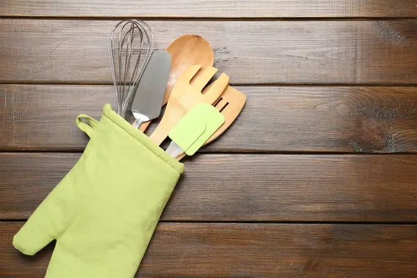 Ahşap masadaki fırın eldiveninde farklı mutfak aletleri, üst manzara. Metin için boşluk
