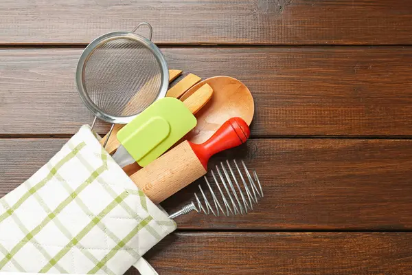 Ahşap masadaki fırın eldiveninde farklı mutfak aletleri, üst manzara. Metin için boşluk