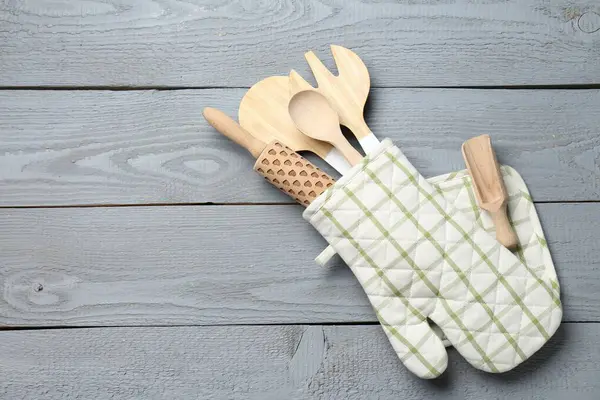 Fırın eldivenindeki farklı mutfak aletleri açık gri ahşap masa, üst manzara. Metin için boşluk