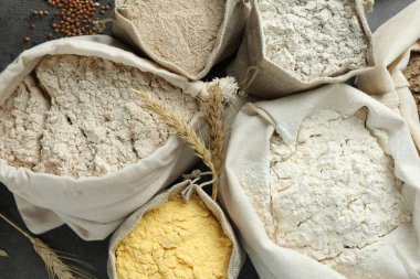 Gri masadaki poşetlerdeki farklı un türleri, düz yatıyordu.