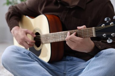 İçerde gitar çalan adam, yakın plan.