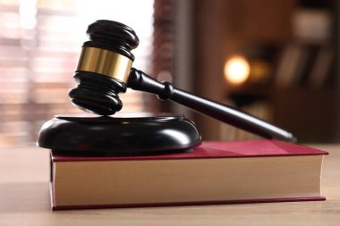 Yargıç tokmağı ve kitabı kapalı bir masa üzerinde, yakın plan.