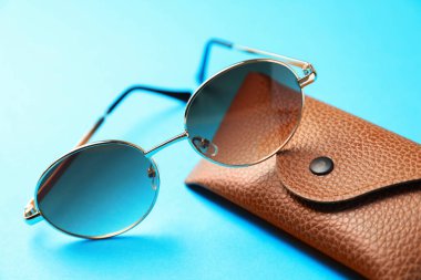 Açık mavi arka planda şık gözlüklü çanta, yakın plan