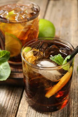 Küba libre kokteylini ahşap masada nane şekeri ile tazeliyorum.