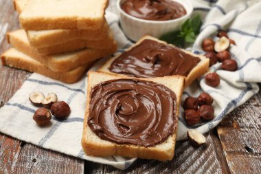 Çikolatalı fındıklı tostlar, ahşap masada fındık ve nane, yakın plan.