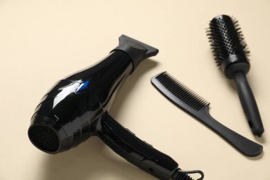 Bej arka planda yuvarlak fırça, tarak ve kurutucu, yakın plan