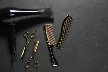 Siyah desenli arka planda farklı saç şekillendirme araçları, düz yatış. Metin için boşluk