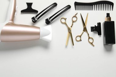 Beyaz arka planda farklı saç şekillendirme araçları, düz yatış. Metin için boşluk