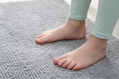 Evdeki yumuşak halıdaki kız, yakın plan. Metin için boşluk