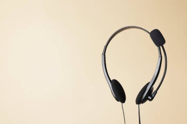 Bej arkaplanda mikrofonu olan kulaklık, metin için boşluk