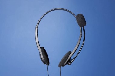 Mavi arka planda mikrofonlu kulaklık.